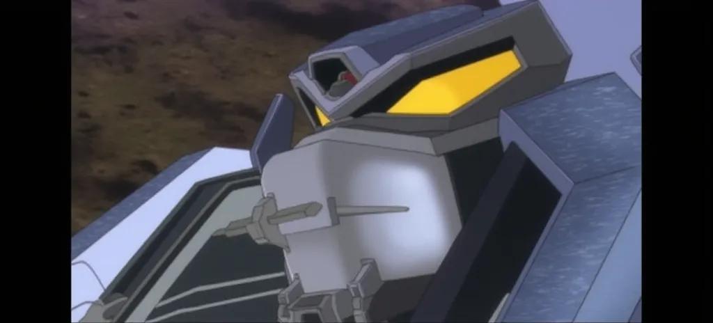 An anime-style mecha robot with a predominantly grey and blue color scheme, featuring angular armor plating and intricate mechanical details. The design includes a cross emblem on the chest and yellow accents on the sides. The robot is standing upright, showcasing its robust and imposing structure. 