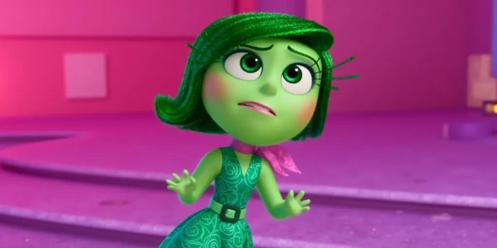 A character from the animated movie "Inside Out" named Disgust. She is depicted with bright green skin and short, green hair. She is wearing a green dress with an intricate swirl design and has a pink scarf around her neck. The background features pink and purple tones.